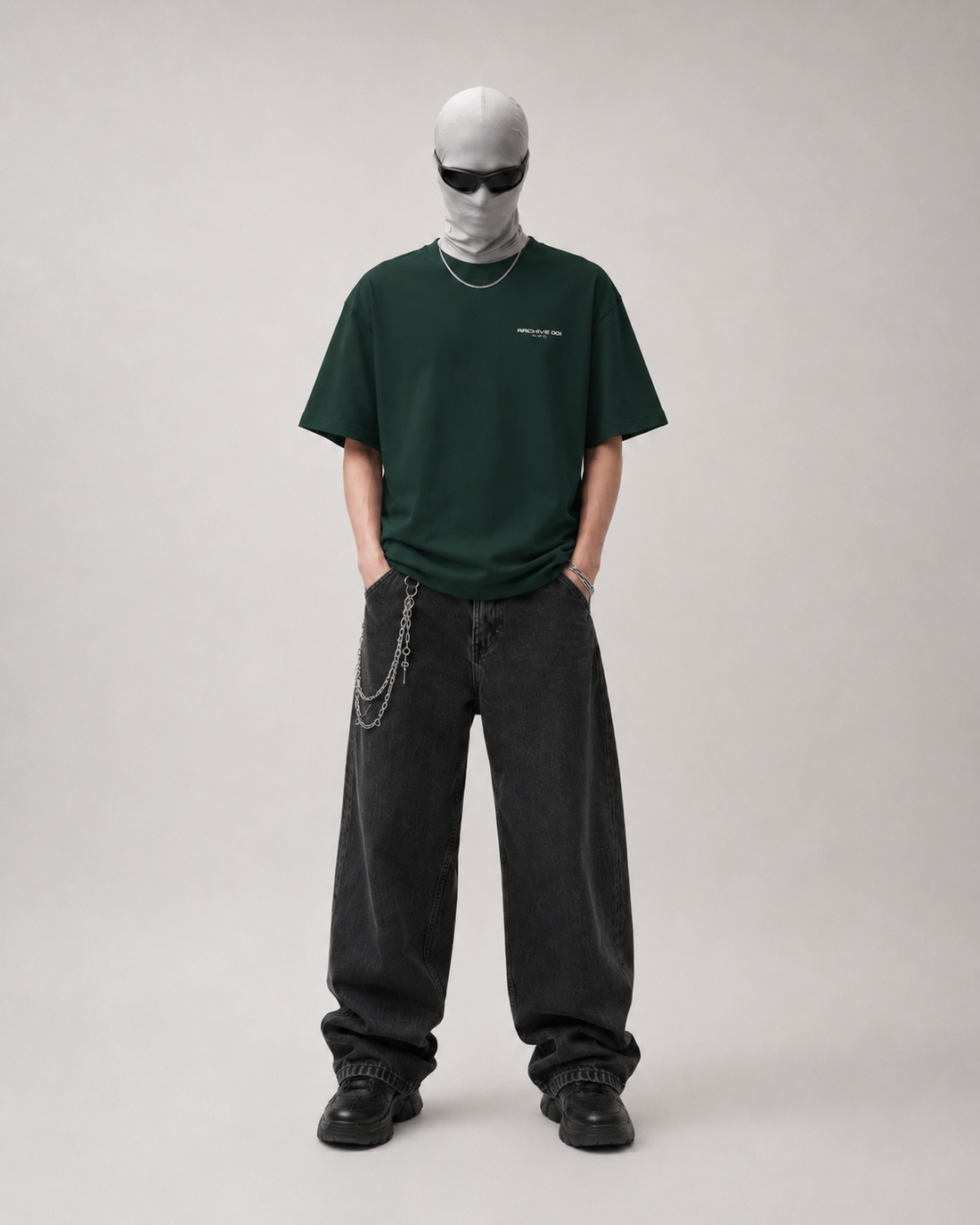 Person wearing a green t-shirt and black pants on a plain background