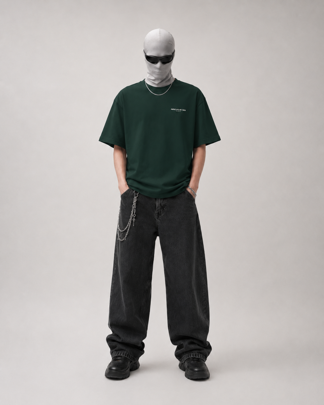 Person wearing a green t-shirt and black pants on a plain background